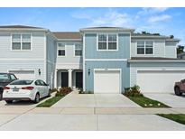 Charming light-blue townhome showcases a clean-looking garage door and well-manicured landscaping at 2949 Clever Ln, Winter Park, FL 32792