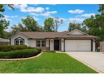 Charming one-story home with a well-manicured lawn and an attached two-car garage at 352 Inglenook Cir, Winter Springs, FL 32708