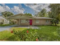 Charming single-story home with a covered parking area and a vibrant red front door at 4524 King Cole Blvd, Orlando, FL 32811