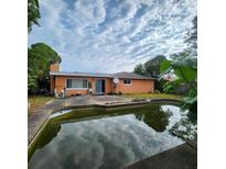 View of the backyard with a patio and a pool reflecting the sky, showing an outdoor living space at 4840 Judy Ann Ct, Orlando, FL 32808