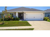 Charming single-story home with a well-manicured lawn and a two-car garage at 871 Orleans Dr, Eagle Lake, FL 33839