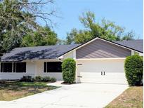Charming single-story home with a well-manicured lawn, attached two car garage and a modern roof at 107 Hilltop Dr, Longwood, FL 32750