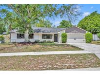 Charming single-story home with well-maintained lawn, mature trees, and a two-car garage at 107 Hilltop Dr, Longwood, FL 32750