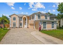 An exterior front view showcasing an elegant two-story home with a driveway and landscaping at 1240 Falconcrest Blvd, Apopka, FL 32712