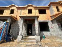 Unfinished townhome with block construction, prepped for finishes and featuring a covered entryway at 15345 Burgtheater Dr, Winter Garden, FL 34787