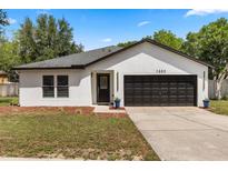 Charming single-story home featuring a two-car garage, fresh paint, and tidy landscaping at 1552 Whooping Dr, Groveland, FL 34736