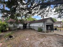 Charming single-story home with a combination of white and gray brick, complemented by mature trees at 2558 El Capitan Dr, Sanford, FL 32773