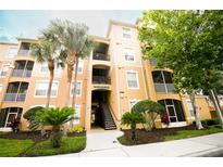 Condo building with lush landscaping, palm trees, and a well-maintained facade at 2788 Almaton Loop # 202, Kissimmee, FL 34747