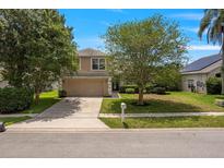 Charming two-story home with a well-manicured lawn, mature trees, and an attached two-car garage at 2853 Strand Cir, Oviedo, FL 32765