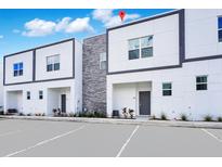 Modern townhome exterior with clean lines, gray accents, and ample parking space for residents and visitors at 348 Famagusta Dr, Davenport, FL 33896