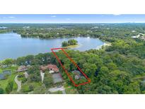 Breathtaking aerial view of a lakefront property with mature trees, offering serene privacy and natural beauty at 4107 Gabriella Ln, Winter Park, FL 32792