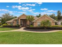 Charming single-story brick home featuring a manicured lawn and inviting walkway leading to the front door at 441 Hightower Dr, Debary, FL 32713
