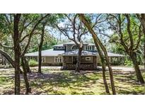 Stunning home exterior with mature trees and inviting facade at 5655 Oak Hollow Ln, Oviedo, FL 32765
