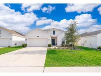 Charming single-Gathering home with a well-manicured lawn and attached two-car garage at 6984 Dilly Lake Ave, Groveland, FL 34736