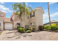 Charming two-story home with a red tile roof, paver driveway, and well-maintained landscaping at 822 Brunello Dr, Davenport, FL 33897