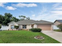 Charming single-story home boasts a well-manicured lawn, lovely landscaping, and a convenient two-car garage at 842 Amidon St, Deltona, FL 32725