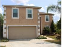Two-story home featuring an attached two-car garage, neutral stucco siding, and decorative white trim at 1009 Ronlin St, Haines City, FL 33844