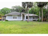 Charming single-story home with a well-manicured lawn and mature trees at 1430 Arrowhead Trl, Deltona, FL 32725