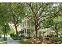 Beautiful multi-story home with multiple balconies, lush landscaping, and mature shade trees create an inviting and picturesque setting at 1630 Common Way Rd # 203, Orlando, FL 32814