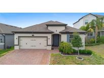 Charming single-story home featuring a brick driveway and well-manicured landscaping at 17199 Hickory Wind Dr, Clermont, FL 34711