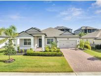 Charming single-story home showcasing a brick driveway, well-maintained landscaping, and a welcoming entrance at 17333 Hickory Wind Dr, Clermont, FL 34711