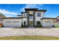 Stunning two-story home featuring a modern design, three-car garage, and beautifully landscaped front yard at 182 N Phelps Ave, Winter Park, FL 32789