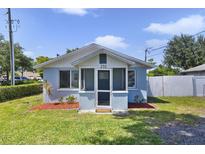 Charming home with a cozy, screened porch entry, landscaped front yard, and a white picket fence at 233 E Church Ave, Longwood, FL 32750