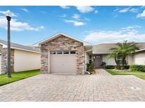 Charming single-story home with a stone-accented facade and a well-manicured lawn with palm tree at 2640 Shelby Ruth Pl, St Cloud, FL 34769