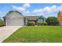 Charming single-story home featuring an attached garage and a well-manicured front lawn at 2681 Debany Rd, Kissimmee, FL 34744