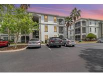 Condominium building exterior showcasing balconies, lush landscaping, and ample parking at 2717 Maitland Crossing # 207, Orlando, FL 32810