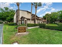 Inviting exterior of a condo featuring well-maintained landscaping and a sign for Club Villas at 2924 S Semoran Blvd # D2, Orlando, FL 32822