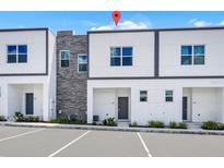 Modern townhome featuring contemporary design, stone accents, and ample parking for residents and guests at 296 Famagusta Dr, Davenport, FL 33896