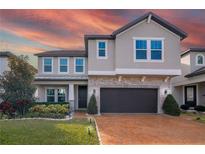 Charming two-story home with stone accents, manicured landscaping, and a brick driveway at 3310 Stonewyck St, Orlando, FL 32824