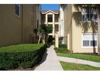 Well-maintained exterior view of the apartment buildings with green shrubbery and concrete walkway at 413 Summit Ridge Pl # 215, Longwood, FL 32779
