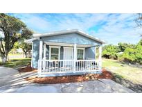 Charming blue home with a white picket porch, perfect for enjoying sunny afternoons at 509 Grove Ave, Orlando, FL 32805