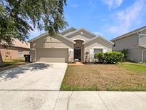 Charming single-story home featuring a well-maintained front yard and two-car garage at 5236 Shale Ridge Trl, Orlando, FL 32818