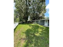 Spacious backyard featuring mature trees, a well-kept lawn and a white picket fence at 732 Trenton Rd, Lakeland, FL 33815