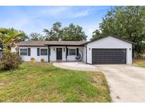Charming single-story home with white brick, dark trim, and a cozy hanging chair on the front porch at 7741 Pine Hollow Ct, Orlando, FL 32822