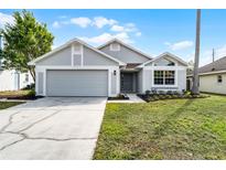 Charming single-story home with gray exterior, well-maintained lawn, and attached two-car garage at 831 Islander Ave, Orlando, FL 32825