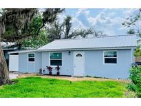 Charming single-story home with a metal roof, fresh blue paint, and inviting front yard at 934 Savannah Ave, Lakeland, FL 33815