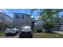 Charming two-story home with a well-maintained lawn and paved driveway and a 2-car garage at 10658 Bannan St, Orlando, FL 32832