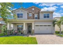 Beautiful two-story home featuring stone accents, covered porch and a paved driveway leading to a two car garage at 13139 Stanthorne Ave, Orlando, FL 32832