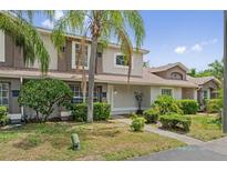 Charming townhouse exterior with tropical landscaping and a well-maintained lawn on a sunny day at 14820 Laguna Beach Cir, Orlando, FL 32824