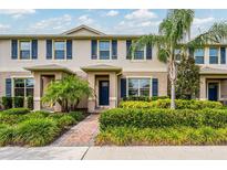 Charming townhouse featuring a well-maintained lawn, blue shutters, and a brick walkway at 16162 Arbor Crest Aly, Winter Garden, FL 34787