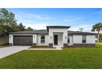 Modern home featuring a black garage door, neutral colors, and dark stone accents at 18743 Overton St, Orlando, FL 32833