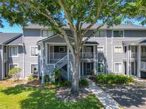 Inviting condo exterior with lush lawn and mature shade tree at 2216 Stonington Ave # 2216, Orlando, FL 32817