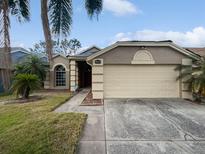 Charming single-story home featuring a two-car garage, neutral stucco, and lush tropical landscaping at 2226 Newt St, Orlando, FL 32837