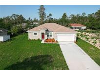 Charming single-Gathering home featuring a well-manicured lawn and inviting red front door at 2531 Sw 167Th Loop, Ocala, FL 34473