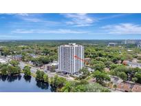 Stunning exterior view of a condo in high rise building with beautiful landscaping and a lake at 400 E Colonial Dr # 1202, Orlando, FL 32803