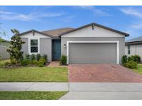 Charming single-Gathering home with a brick driveway, two-car garage, and well-maintained landscaping at 523 Tortugas St, Haines City, FL 33844